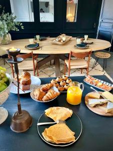 einen Tisch mit Gebäck und Orangensaft in der Unterkunft Villa Louisa in Saint-Malo