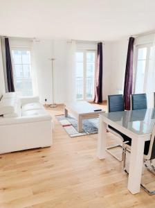 ein weißes Wohnzimmer mit einem Tisch und einem weißen Sofa in der Unterkunft Appartement 6 pers. à Disneyland Paris in Chessy