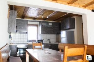 a kitchen with a table and chairs and a kitchen with a refrigerator at Adria in Kupres