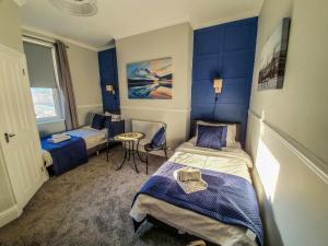 卡莱尔Abbey Court Guest House的有两张床和一张桌子的房间