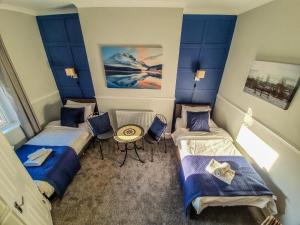 卡莱尔Abbey Court Guest House的有两张床和一张桌子的房间
