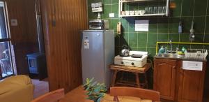 een keuken met een koelkast en een wastafel bij Cabañas Rukas Licantén in Licantén