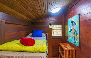 a small room with a bed in a wooden room at Piton Bungalows Ecolodges in Deshaies