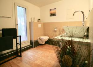 a bathroom with a toilet and a sink and a window at Hof Seebrookquelle in Schlesen +34 photos