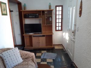 a living room with a couch and a flat screen tv at Casa en el centro de La Paloma in La Paloma