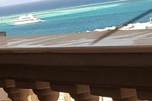 Blick auf einen Strand mit einer Yacht im Wasser in der Unterkunft ELITE VIP - Apartment with sea VIEW - swimming pool - BBQ terrace - near BEACH in Hurghada