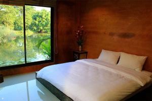 a bedroom with a bed and a window at Saikaew Resort in Chiang Rai