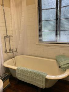 a white bath tub in a bathroom with a window at Coochin Cottage, Beerwah in Beerwah