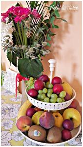 two baskets of fruit on a table with a vase of flowers at Hotel La Selce in Monselice