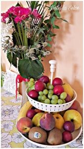 dos cestas de fruta en una mesa con un jarrón de flores en Hotel La Selce, en Monselice