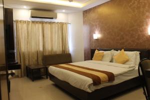 um quarto de hotel com uma cama e uma janela em Hotel Kanak em Ahmedabad