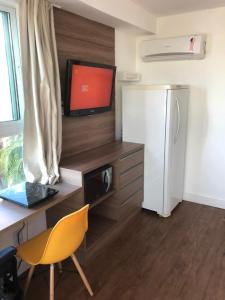 a room with a desk with a computer and a refrigerator at Flat vista Mar in João Pessoa
