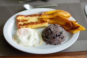 a plate of breakfast food with eggs bread and bananas at Cabinas Eddy B&B in Monteverde Costa Rica