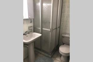 a bathroom with a toilet and a sink and a shower at Amplio y acogedor departamento frente al Mar Sector 4Esquinas in La Serena +13 photos