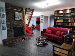 a living room with a red couch and a fireplace at Vila Ana in Donja Ralja