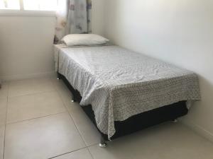 a small bedroom with a bed with a blanket on it at Mediterrâneo 507 - Todo Equipado, Ar Condicionado, Churrasqueira na Varanda, Internet Fibra 600MB, Estacionamento Grátis in Cabo Frio