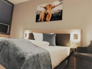 a bedroom with a bed with a picture of a cow on the wall at Hotel & Restaurant Alte Molkerei Kölleda in Kölleda