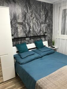 ein Schlafzimmer mit einem großen Bett mit blauen Kissen in der Unterkunft Annabella Vendégház in Hajdúszoboszló