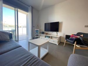 a living room with a couch and a flat screen tv at New and cosy apartment - 4 min walk from the beach - La Tejita - El Medano in Granadilla de Abona