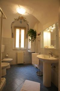 bagno con 2 servizi igienici, lavandino e specchio di Mondovì Ridente a Mondovì