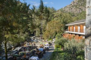 un giardino con tavoli e sedie accanto a un fiume di Dominique Colonna a Corte