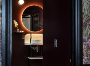 a bathroom with a sink and a mirror at Naumi Studio Wellington in Wellington