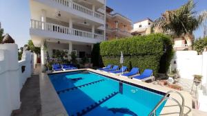 a villa with a swimming pool in front of a building at Luxor VIP Apartments in Luxor