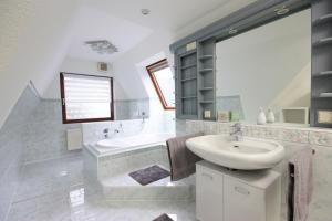 a bathroom with a sink and a tub and a toilet at WEIßE HÖHEN -Ferienhaus, Dibbersen bei Hamburg in Buchholz in der Nordheide +33 photos