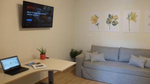 - un salon avec un canapé et une table avec un ordinateur portable dans l'établissement Elata-Apartments, à Thasos