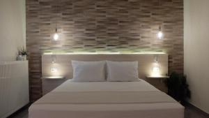 a bedroom with a bed with two lights above it at Elata Apartments in Limenas