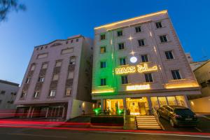 un edificio con una señal verde en el costado. en ماس للشقق الفندقية الفاخرة en Yeda