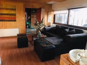 a living room with a black couch and a table at Hotel HF in Farellones