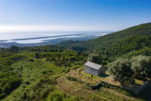 ein altes Haus auf einem Hügel mit dem Ozean im Hintergrund in der Unterkunft Appartement neuf entre mer et montagne. in Furiani