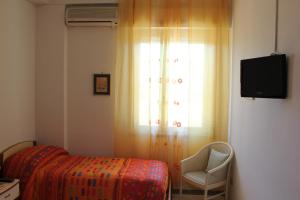 a bedroom with a bed and a chair and a window at Domus Felix in Ercolano