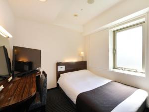 
a hotel room with a bed and a desk at APA Villa Hotel Nagoya Marunouchi Ekimae in Nagoya
