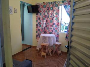 a room with a table and two stools and a window at Kitnet novo, completo com AR, 10km da Igreja do Bonfim e 13km do Pelourinho, Centro. in Salvador