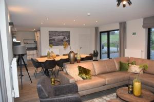 un soggiorno con divano e tavolo di Rochehaut, Les Semoiselles, Villa Isabelle a Bouillon