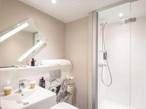 La salle de bains est pourvue d'un lavabo et d'une douche. dans l'établissement ibis budget Nice Californie Lenval, à Nice