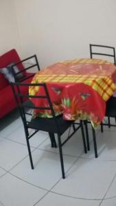 una mesa y sillas con una manta roja y amarilla. en résidences aux saveurs des mangues, en Baillif