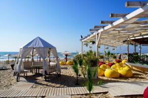 a beach with a table and chairs and a tent at Family Hotel Yulian in Kranevo