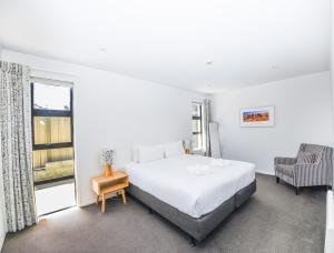 a bedroom with a large bed and a window at Tenby Apartments in Wanaka