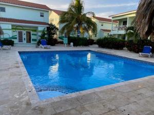 a large blue swimming pool in front of a house at Blue Lagoon Apartment in Lagun +21 photos