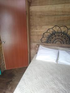 
a bed in a bedroom with a wooden headboard at Nuestra Cabañita in Playa Blanca
