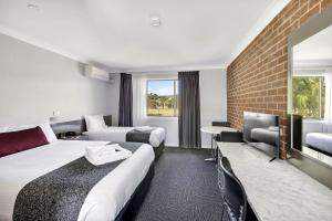 um quarto de hotel com duas camas e uma televisão em Bushman's Motor Inn em Lithgow