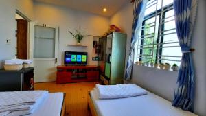 - un salon avec 2 lits et une télévision dans l'établissement Sena home 2nd*near Danang Han river*Dragon bridge, à Đà Nẵng