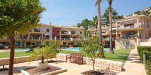 um resort com piscina e palmeiras em Jardines de Montemar II em Benissa