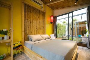 een slaapkamer met een bed en een gele muur bij Homestay CHẤT - Oasis View 1 in Hanoi