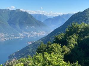 a view of a valley with a city and a lake at Hotel Paradiso Como in Brunate