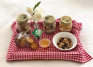 a red and white blanket with jars and a bowl of nuts at Quiet Boutique Generous Breakfast in Palmerston North