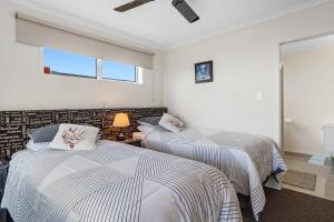 1 Schlafzimmer mit 2 Betten und einem Fenster in der Unterkunft Omokoroa Sea View Apartment in Omokoroa